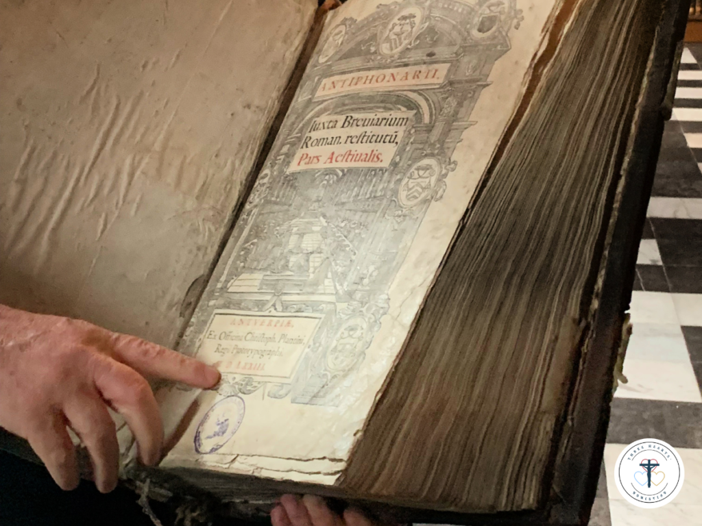 Picture of an open book with a man pointing at some of the words.