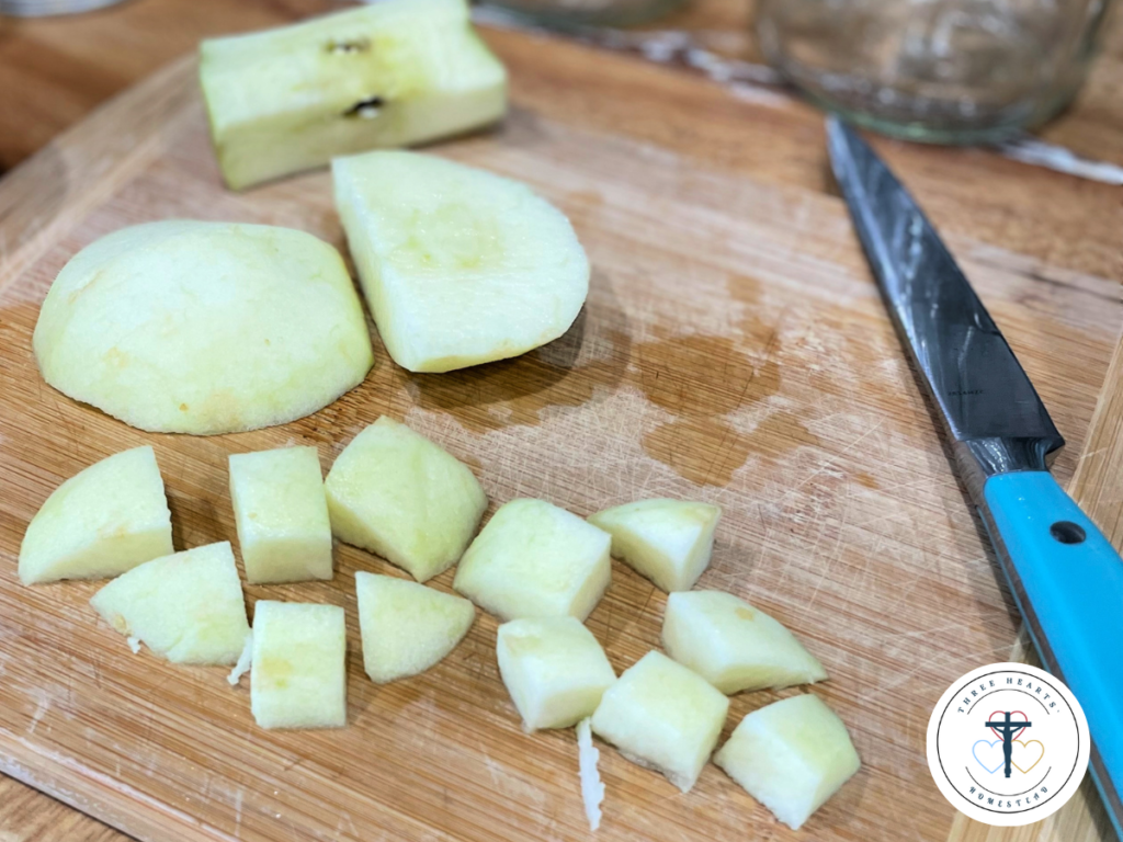 Picture of diced apples on a cutting board next to a knife.