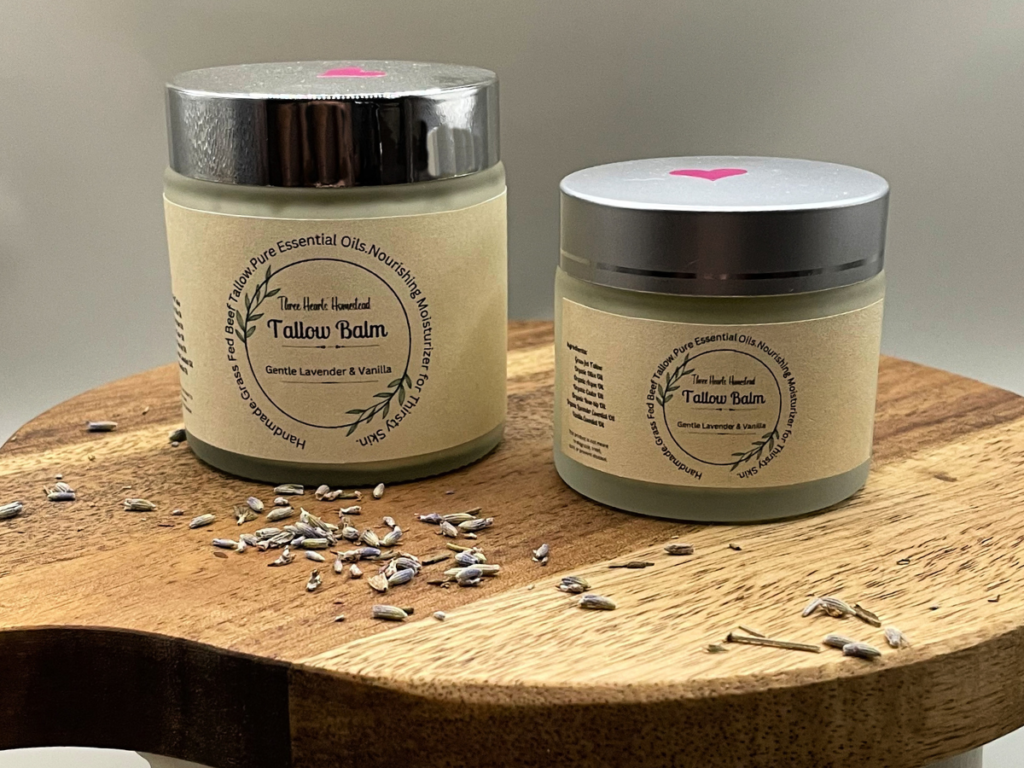 Picture of two jars of lavender face cream on a wooden stand surrounded by lavender buds.