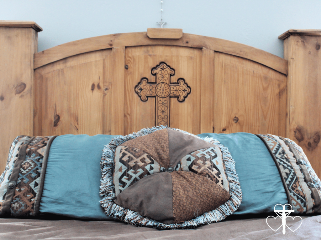 Picture of a wooden headboard and decorative pillows on a made bed.